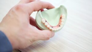 hand holding model of teeth